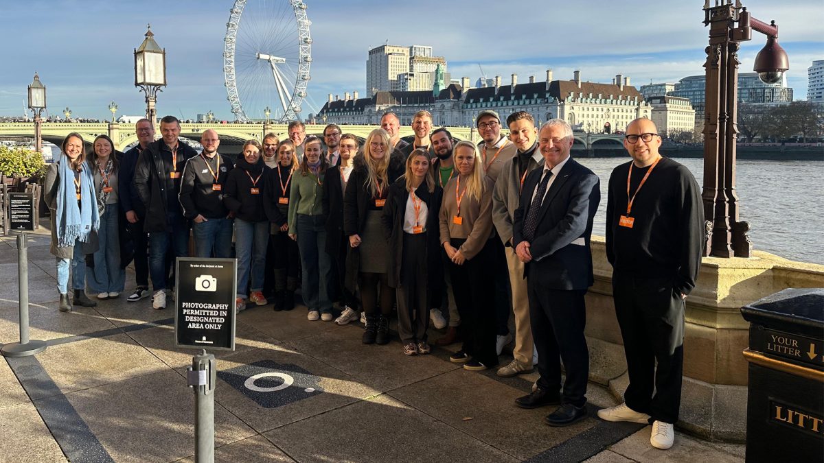 Gruppenfoto von Teilnehmerinnen und Teilnehmern vor der Themse in London, im Hintergrund das London Eye und die Skyline.
